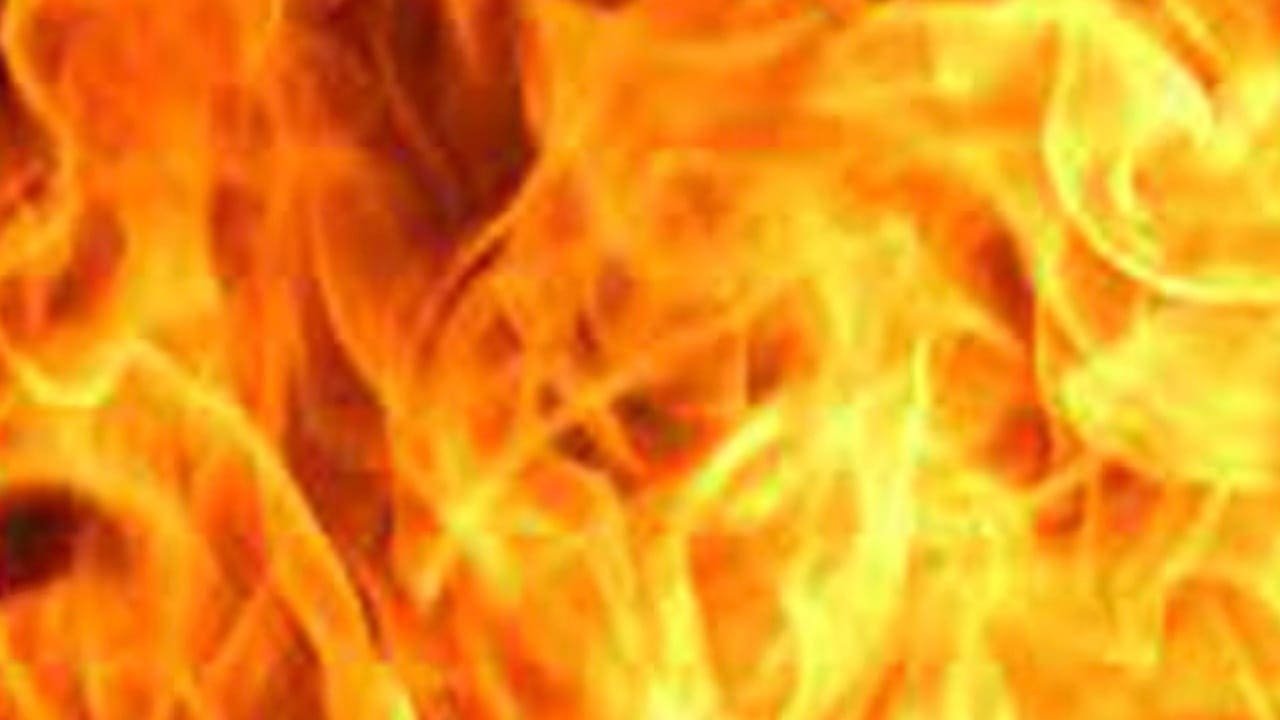 A close-up image of flames with vibrant orange and yellow hues, creating an abstract display of fire. The texture of the flames appears dynamic and fluid.