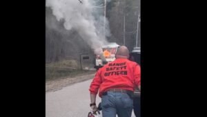 A person wearing a red jacket labeled 
