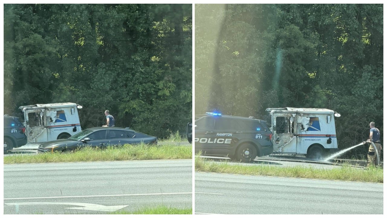 A damaged white delivery van and a black police SUV are stopped beside a highway, with a person spraying water near the van and trees in the background.